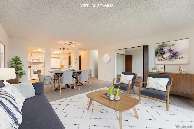 living area featuring light carpet and a textured ceiling