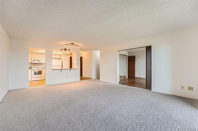 unfurnished living room featuring light carpet and a textured ceiling