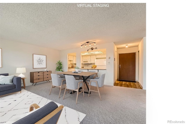 dining area featuring light colored carpet and a textured ceiling