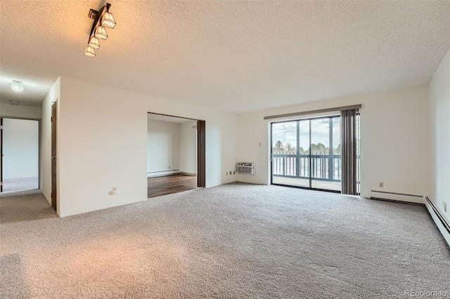 spare room with carpet flooring, a textured ceiling, a wall mounted AC, rail lighting, and a baseboard radiator