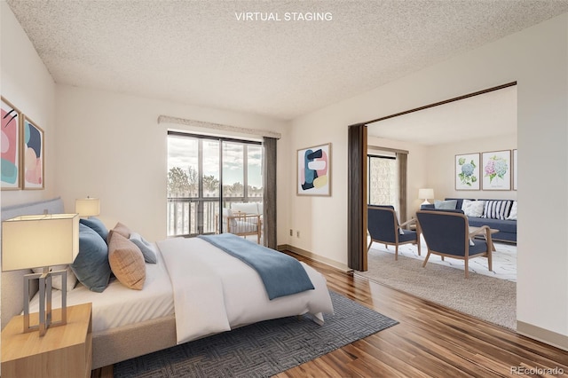 bedroom with wood finished floors, a textured ceiling, and baseboards
