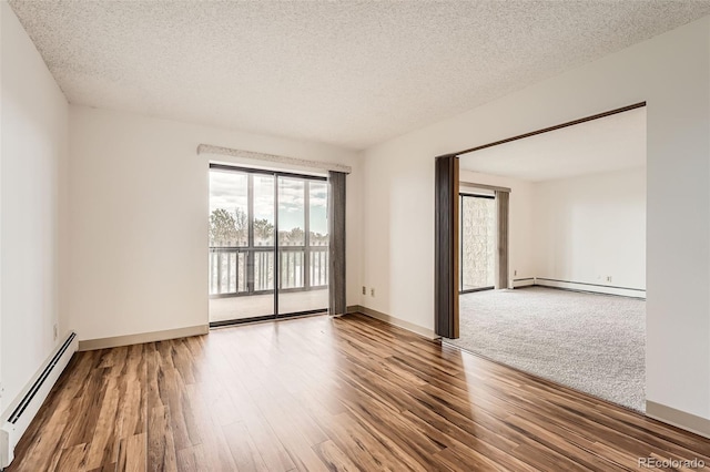 empty room with a baseboard radiator, wood finished floors, a textured ceiling, and baseboards