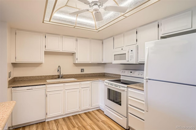 kitchen featuring white appliances, a sink, white cabinets, light wood-style floors, and ceiling fan