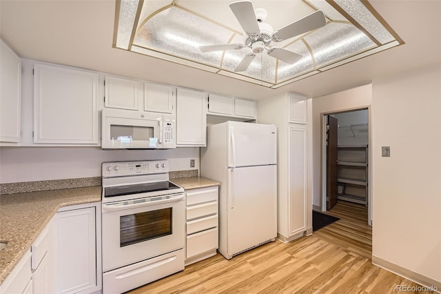 kitchen featuring white appliances, white cabinets, light wood-style flooring, light countertops, and ceiling fan