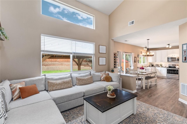 10245 Nottingham Dr, Parker, CO 80134 - living room featuring a towering ceiling, a chandelier, and dark wood-type flooring