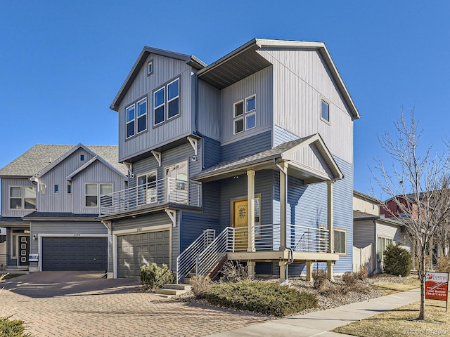 view of front of property featuring a garage, decorative driveway, and a balcony