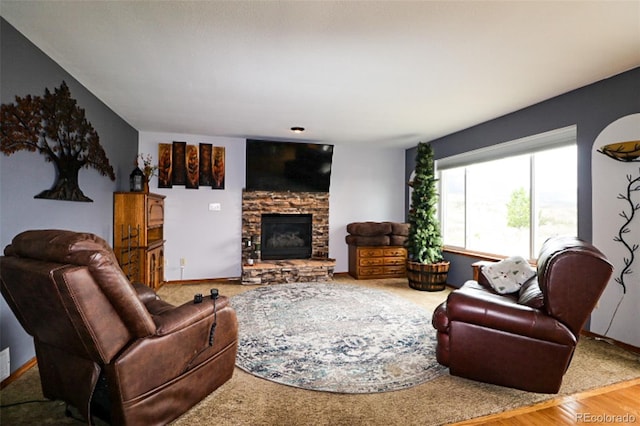 3530 Doolittle Rd, Monument, CO 80132 - living area featuring a stone fireplace, wood finished floors, and baseboards