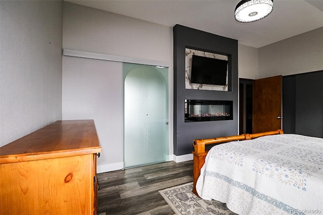 3530 Doolittle Rd, Monument, CO 80132 - bedroom with dark wood-style floors, a closet, baseboards, and arched walkways