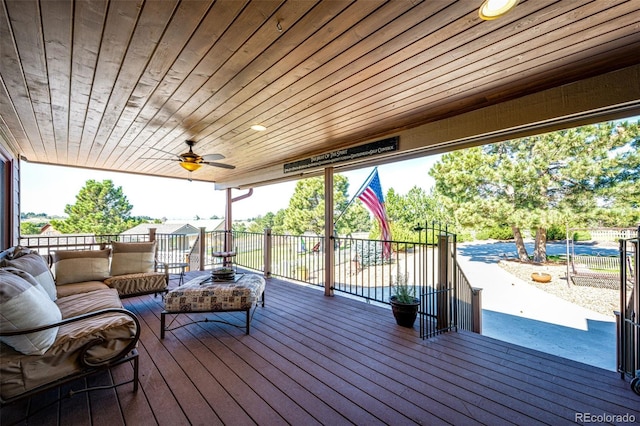 wooden deck with an outdoor living space and ceiling fan