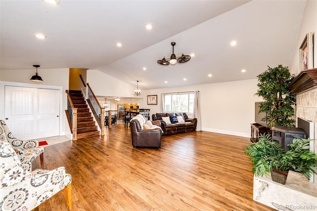 living room with lofted ceiling, a fireplace, and light hardwood / wood-style floors