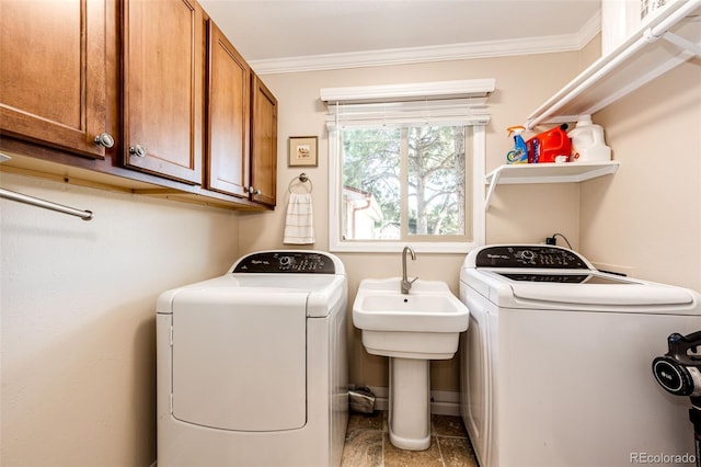 washroom featuring sink, crown molding, washer and clothes dryer, and cabinets