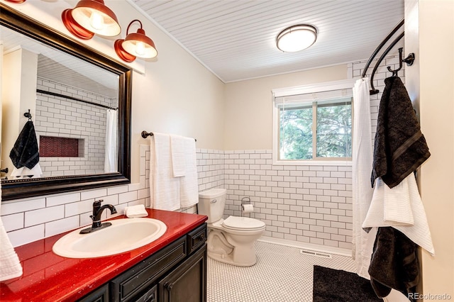 bathroom featuring tile walls, vanity, toilet, tile patterned floors, and a shower with curtain