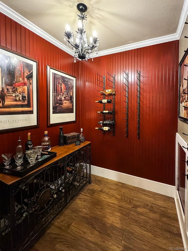 hall with dark hardwood / wood-style floors, wood walls, a chandelier, crown molding, and a textured ceiling