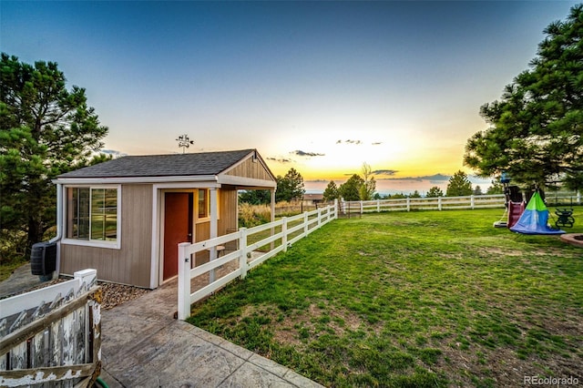 yard at dusk featuring an outdoor structure and cooling unit