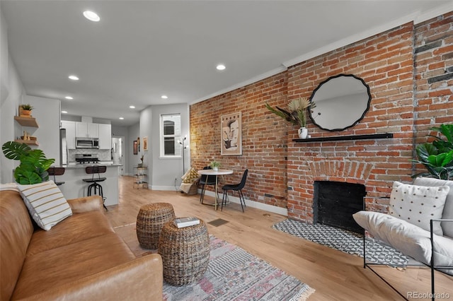 3003 California St, Denver, CO 80205 - living room with light wood finished floors, recessed lighting, ornamental molding, a fireplace, and brick wall