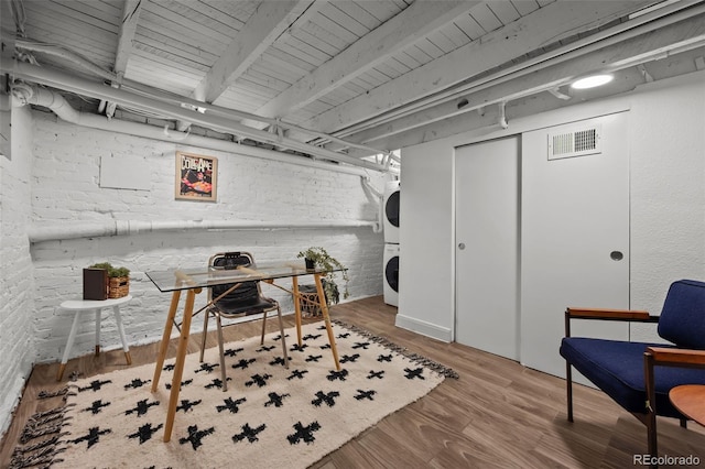 3003 California St, Denver, CO 80205 - finished basement featuring stacked washer / dryer, wood finished floors, and brick wall