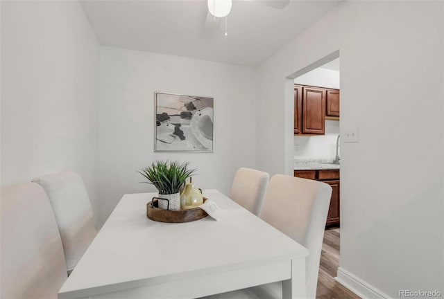 dining space with ceiling fan and hardwood / wood-style floors