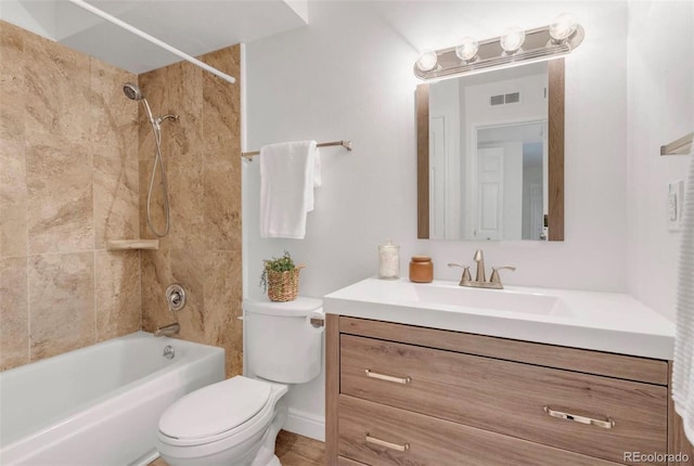 full bathroom with vanity, tiled shower / bath, and toilet