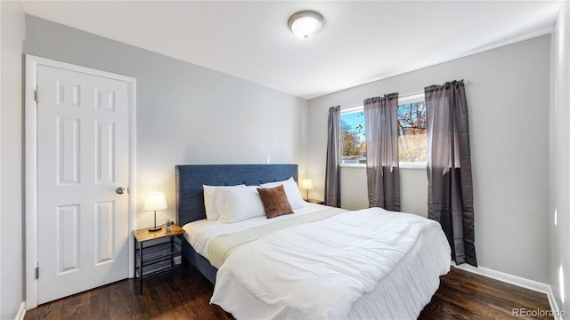 bedroom with dark hardwood / wood-style flooring