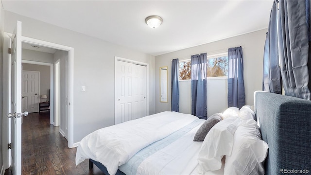 bedroom with dark wood-type flooring and a closet