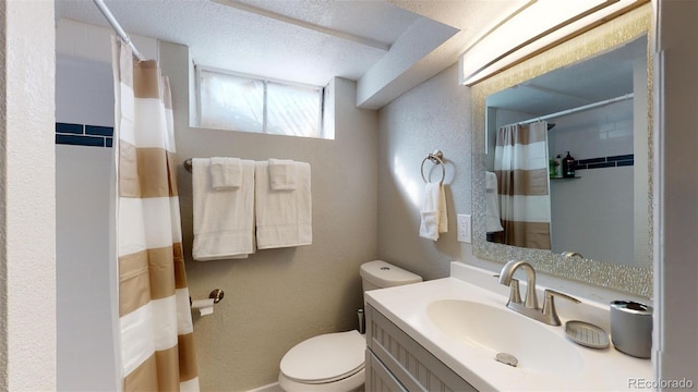 bathroom with a textured ceiling, vanity, and toilet