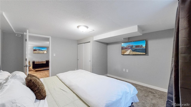 carpeted bedroom with a closet and a textured ceiling