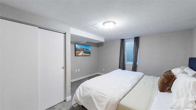 carpeted bedroom with a closet and a textured ceiling