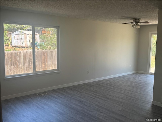 empty room with wood finished floors, a textured ceiling, baseboards, and a ceiling fan