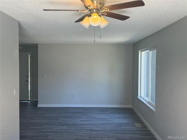 unfurnished room with a textured ceiling, dark wood-style flooring, a ceiling fan, and baseboards