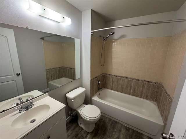 bathroom featuring wood finished floors, shower / washtub combination, toilet, and vanity