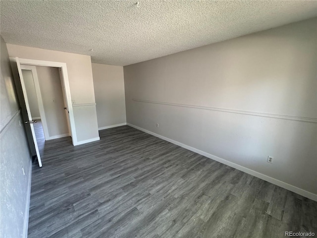 unfurnished bedroom featuring dark wood-type flooring, a textured ceiling, and baseboards