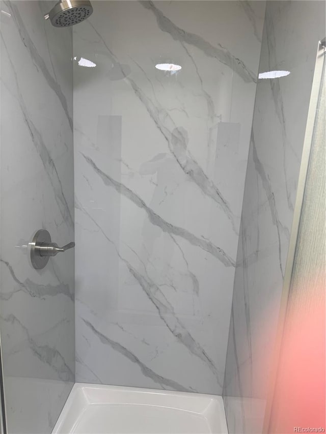 full bath with a marble finish shower