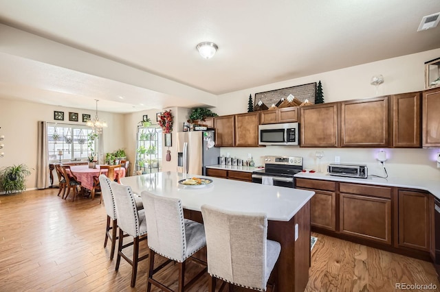 kitchen with visible vents, a breakfast bar area, stainless steel appliances, and light countertops