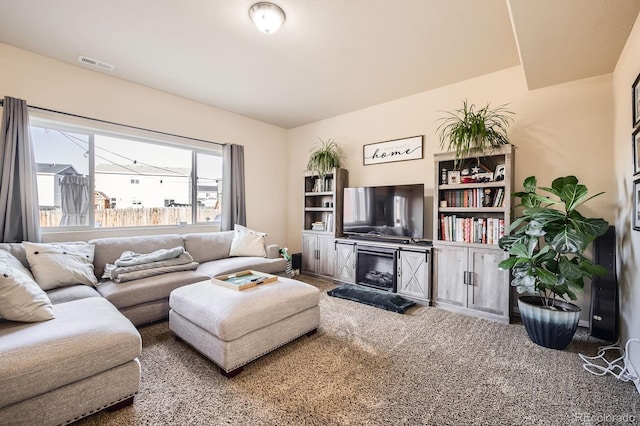 carpeted living room with visible vents and a fireplace