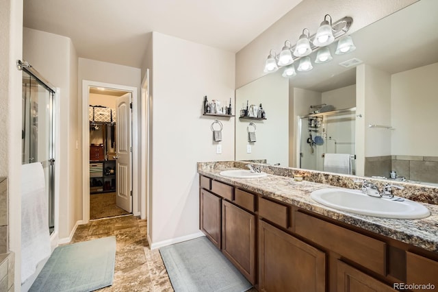 bathroom featuring a spacious closet, visible vents, a stall shower, and a sink