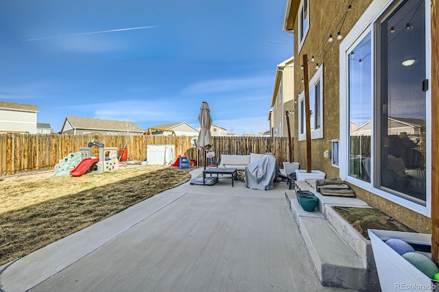 view of patio featuring an outdoor living space, a fenced backyard, and a playground