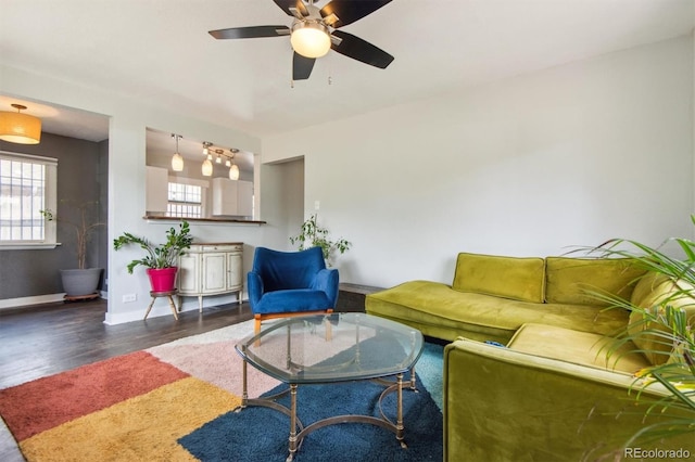 living room with ceiling fan and dark wood-type flooring