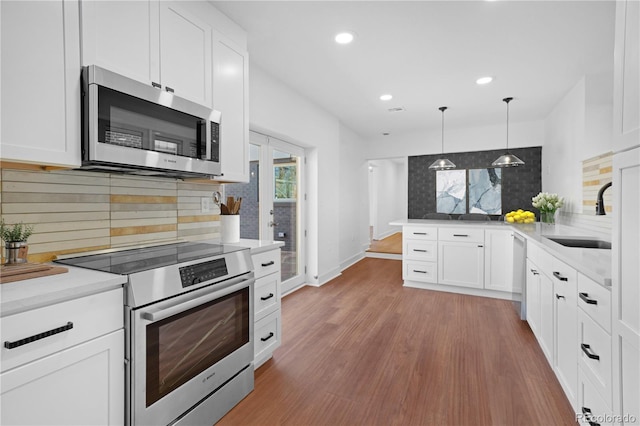 5730 E 19th Ave, Denver, CO 80220 - kitchen featuring appliances with stainless steel finishes, a sink, decorative backsplash, a peninsula, and recessed lighting