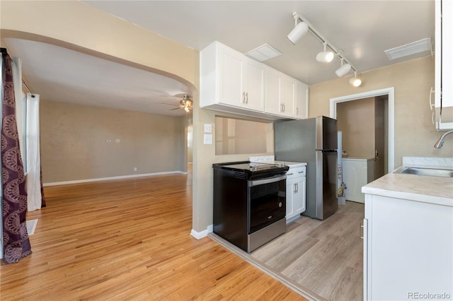 kitchen with sink, light hardwood / wood-style flooring, ceiling fan, appliances with stainless steel finishes, and white cabinetry