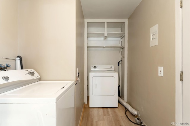 washroom with light wood-type flooring and washing machine and clothes dryer