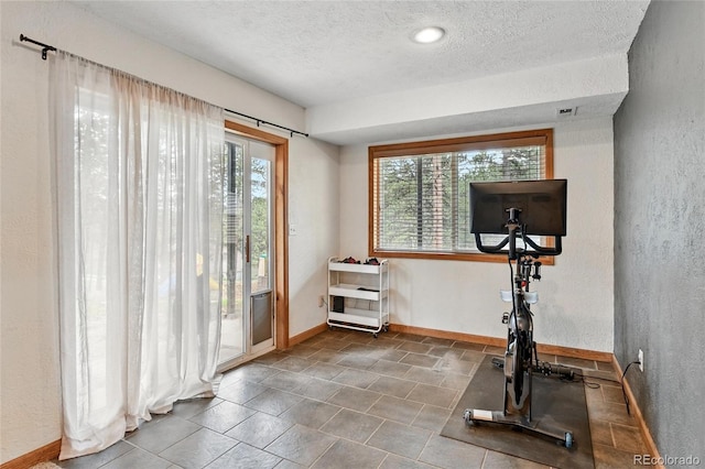 294 Kudu Trl, Bailey, CO 80421 - workout area with a textured ceiling, a textured wall, baseboards, and tile patterned floors