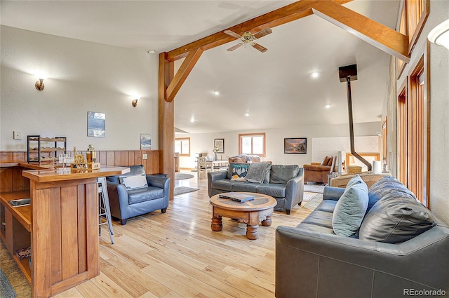 living room with beam ceiling, high vaulted ceiling, light wood-type flooring, and ceiling fan