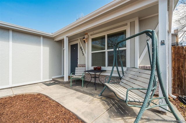 property entrance with stucco siding and covered porch