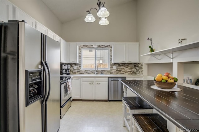 kitchen featuring stainless steel appliances, tasteful backsplash, white cabinetry, and a chandelier