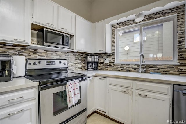 kitchen featuring a sink, decorative backsplash, white cabinetry, and stainless steel appliances