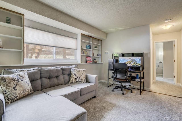 carpeted home office with a textured ceiling and baseboards