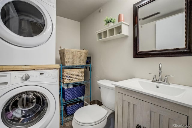 bathroom with toilet, stacked washing maching and dryer, and vanity