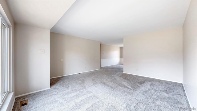 carpeted empty room featuring visible vents and baseboards