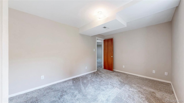 carpeted empty room featuring visible vents and baseboards