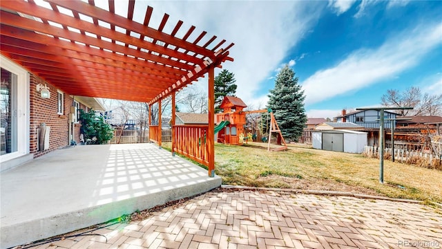 view of patio / terrace featuring a playground, an outdoor structure, a fenced backyard, and a shed